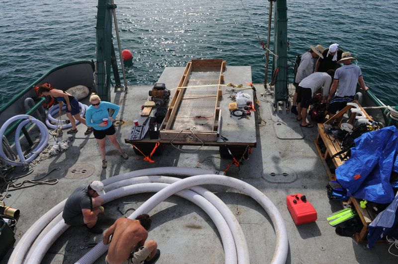 A view of Weatherbird II's stern, showing the floating dock and dredge hose undergoing repairs.