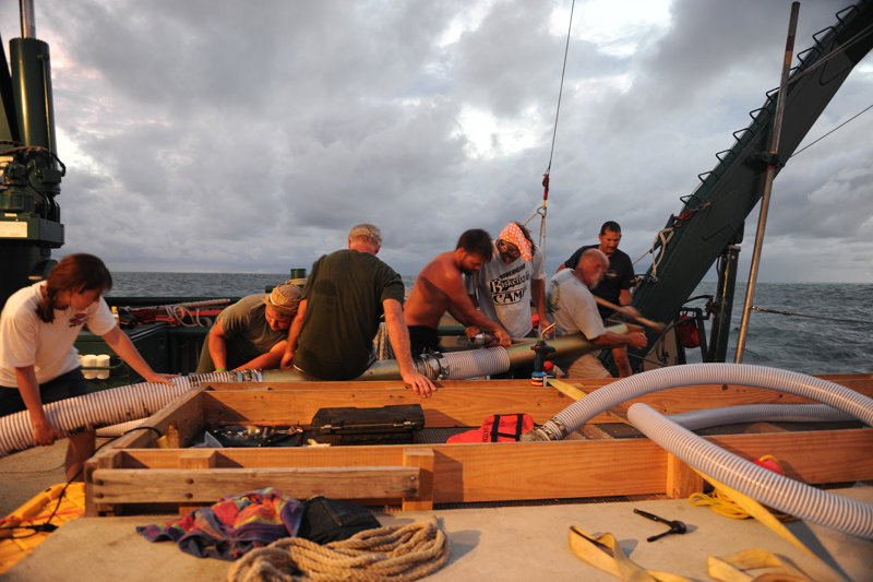 The research team redeploying the dredge hose from the R/V Weatherbird II.