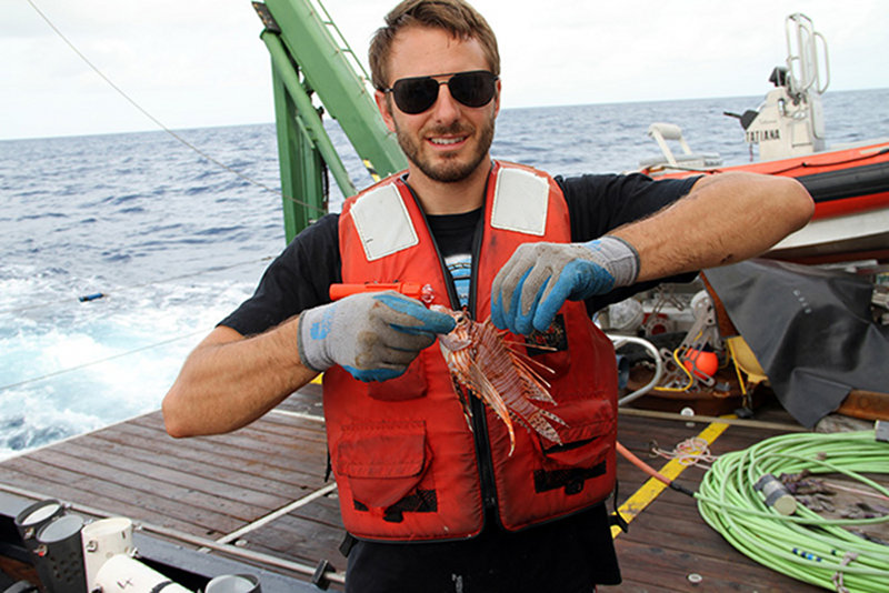 Chris Malinowski holds up a red lionfish.