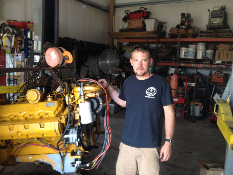 Brendan Burke, LAMP Logistical Coordinator, poses next to the engine of the research vessel Roper, which was removed for necessary maintenance between Cruises 1 and 2. The work was completed at the Xynides Boatyard, owned and operated for generations by one of St. Augustine’s Greek boatbuilding families.