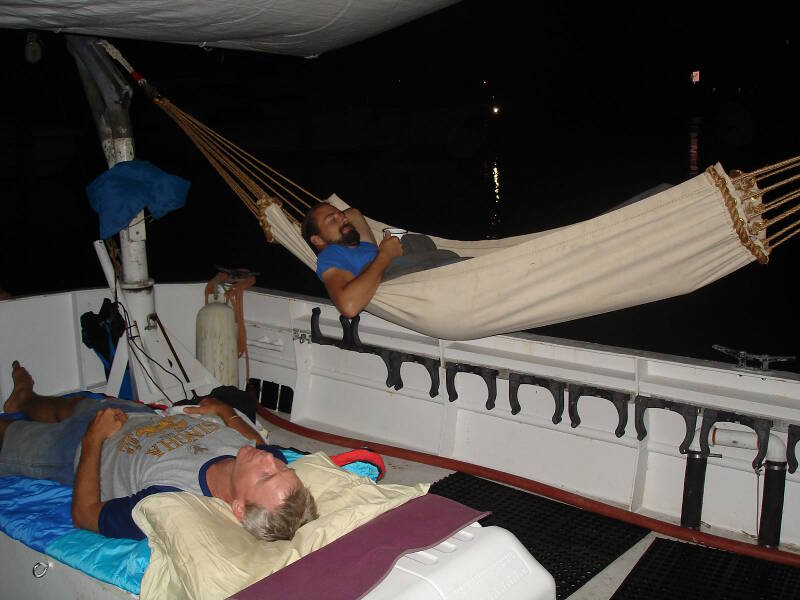 Sam and Brian sleep out on deck tonight, with the canopy overhead protecting them from the occasional light rains coming through. Brian has made his hammock by hand, which is a faithful reproduction based on 18th-century British naval hammocks. The design is well-suited for shipboard life and is quite comfortable.