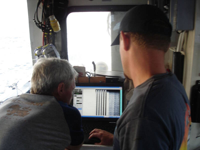 Sam Turner (left) and Brendan Burke (right) inspect the subbottom profiler display at the start of the day, to confirm that the device is working properly. 