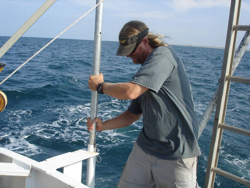 Here I am securing the subbottom profiler at the stern of the boat. Its pole mounting slides up so that we can secure it above water for transit.