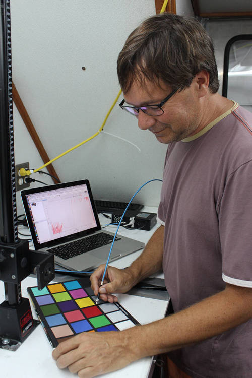 Sönke Johnsen holds the fiber optic probe to a color standard.