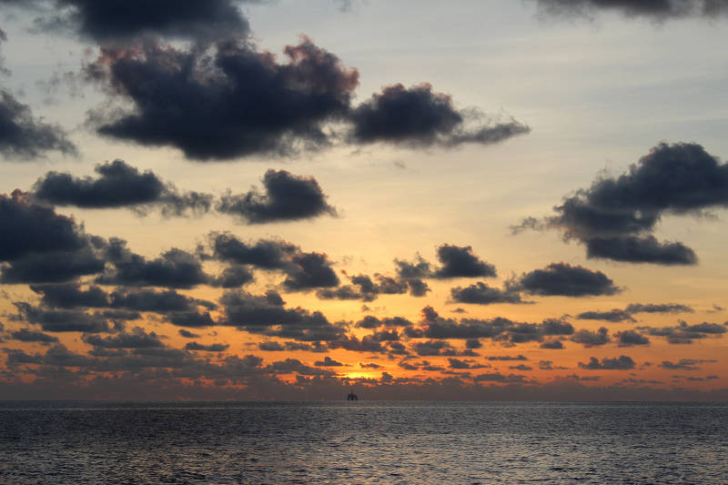 Sunset over a distant oil rig.