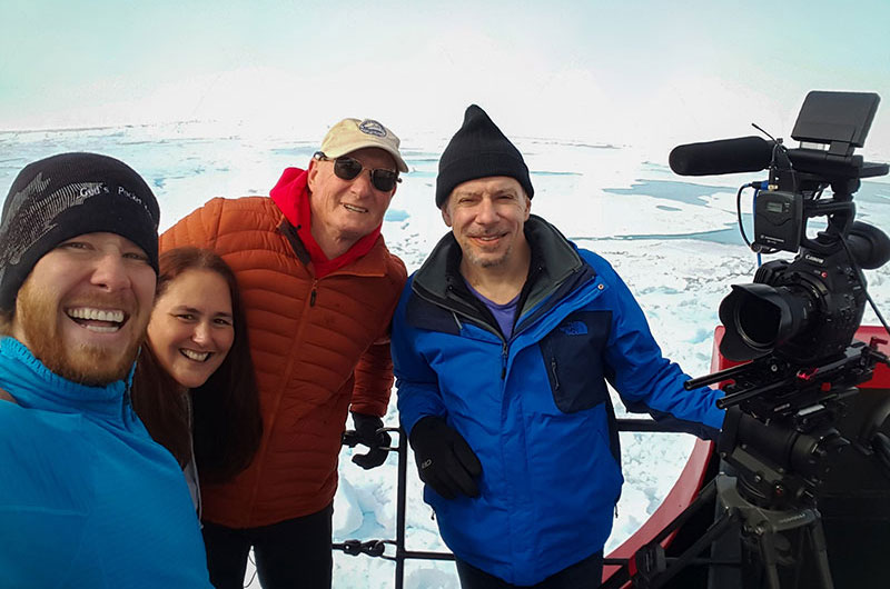 The Microcosm team (Mathew Broughton, Michele Hoffman Trotter, and Michael Caplan) take a photo with Dr. Jeff Welker after an interview on the Healy's bow. 