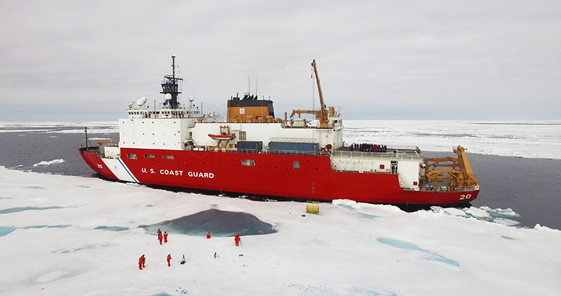 The U.S. Coast Guard Cutter Healy sits alongside an ice floe to allow science operations to occur.