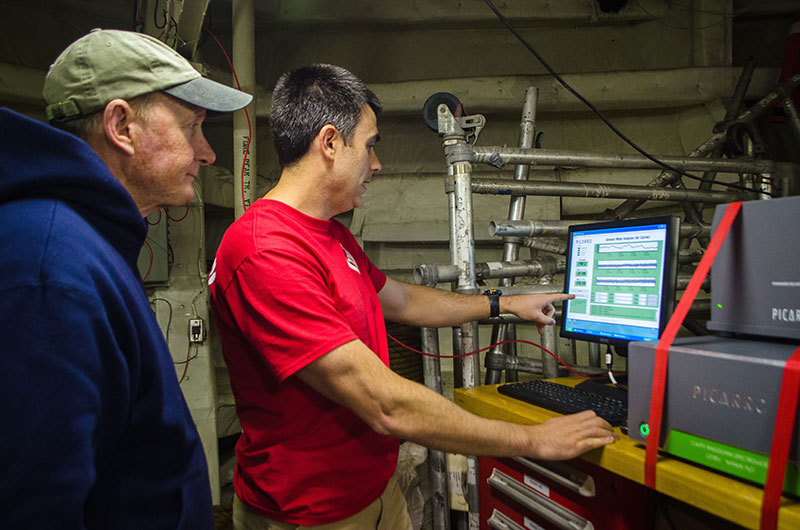 Jeff Welker and Eric Klein look at a spectrometer (endearingly called “Pippin”) that is measuring the oxygen and hydrogen isotopic values of water vapor through a pipe system that leads to the upper bow of the U.S. Coast Guard Cutter Healy.