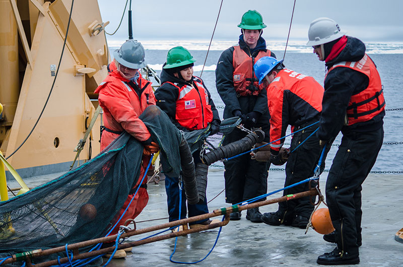 The science conducted during our expedition would not have been possible without the help from the Coast Guard. Here, Coast Guard members assist Kelly Walker with the trawl before deployment.