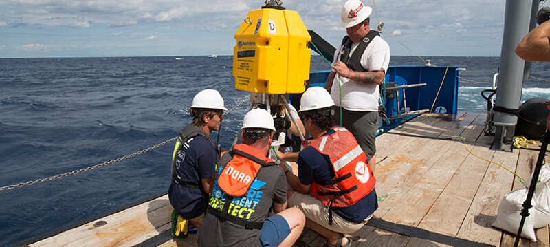 Project team members prepare the transponder pod on board the R/V Baseline Explorer.