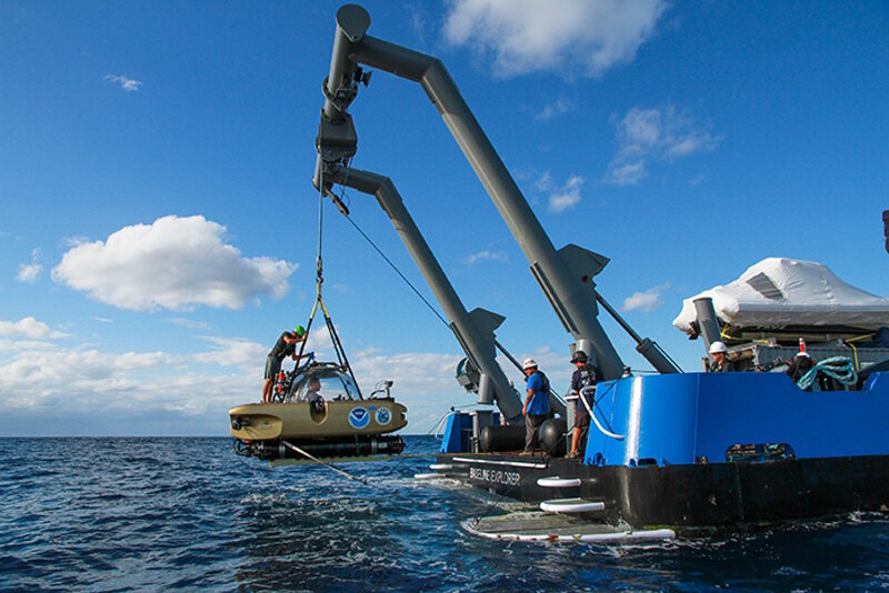 The submersible is being lifted out of the water after a dive.