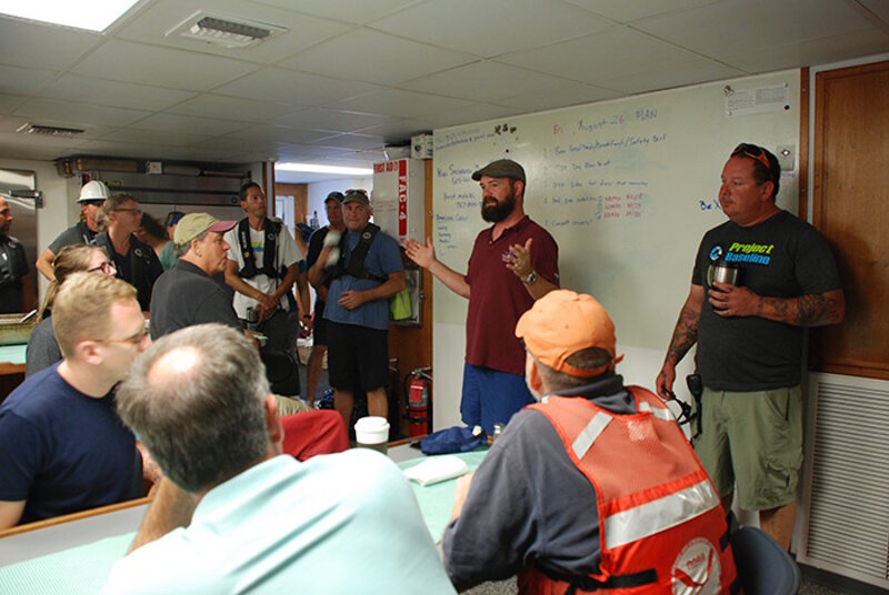 Joe Hoyt (in red shirt) during the morning briefing.