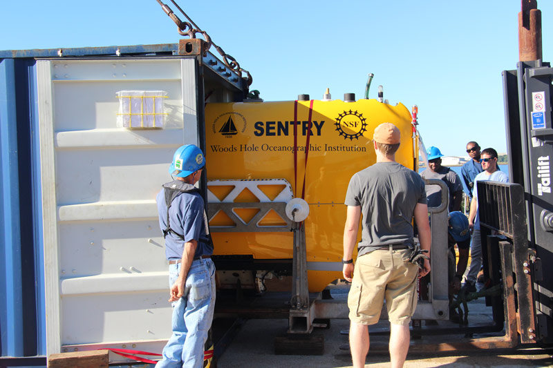 The AUV team and ship’s crew unload Sentry from the shipping container.