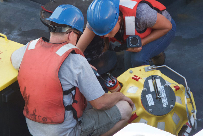 Mike McCarthy and Molly Curran of the AUV team prepare the stationary transponder for deployment.