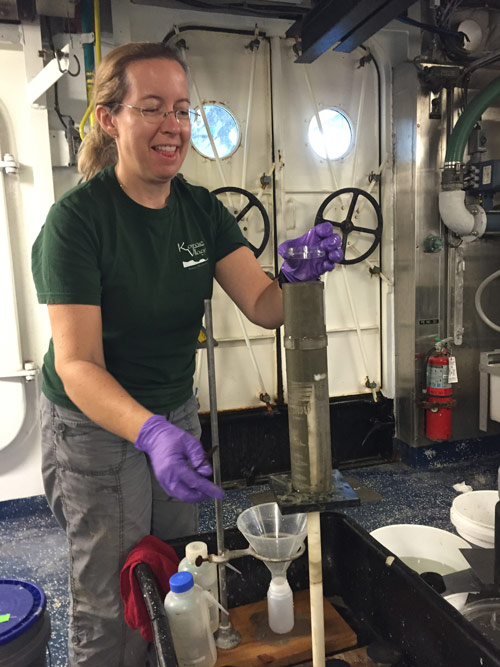 Amanda Demopoulos prepares to slice another centimeter section from the sediment core.