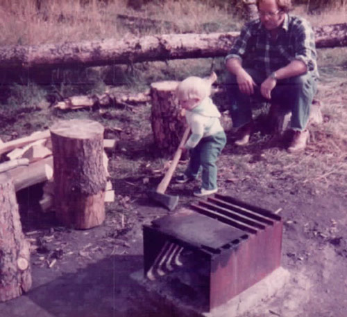 Carl learning how to engineer a campfire at a young age.