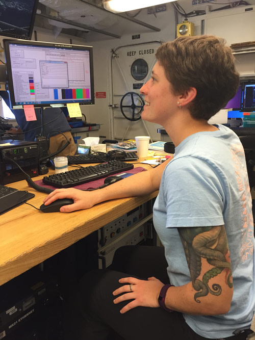Danielle monitoring data in real-time during a CTD deployment. She communicates with the deck and bridge throughout the operation.