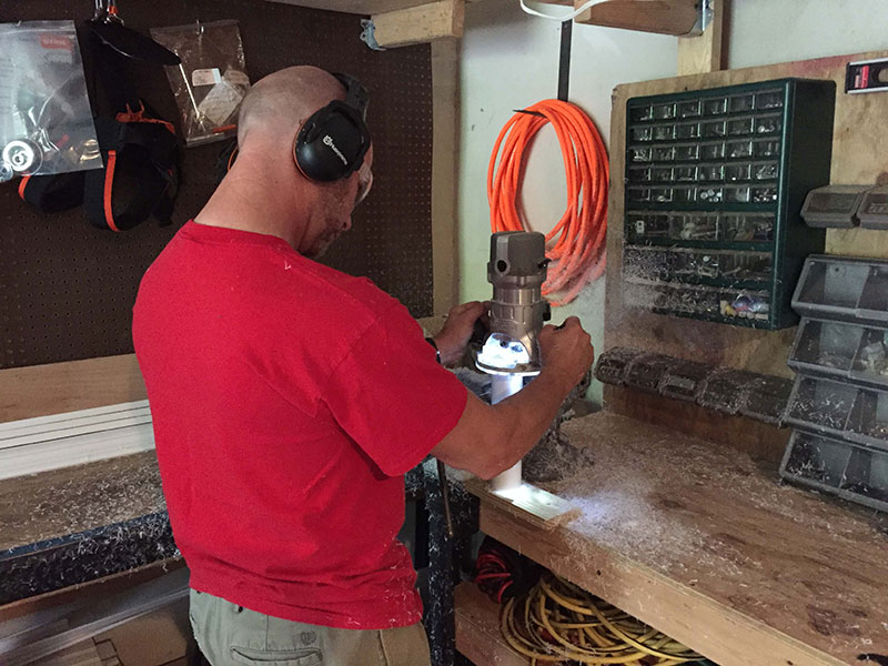 Brad Coffman uses a router to trim the rims of quivers.