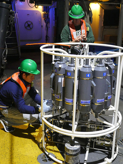 Daniel Wagner (NOAA) and John Gray (University of South Florida) processing water samples collected during CTD (conductivity, temperature, depth) casts to 500 meters depth at Okeanos Ridge on the West Florida slope aboard NOAA Ship Nancy Foster. Information collected by the CTD helps researchers calibrate high-resolution mapping aboard the ship.
