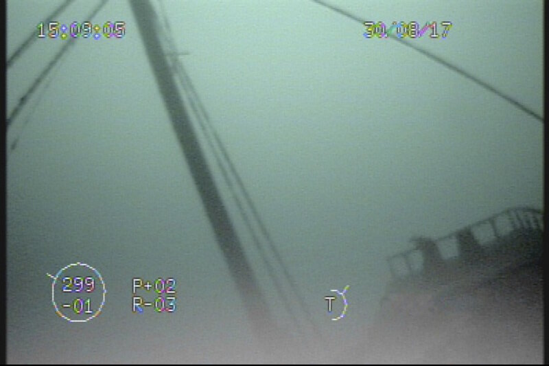 Moving further forward, the ROV pilots followed the mast’s forward stays down to the bow of the wooden bulk carrier. Ambient light was sufficient at this depth to silhouette features against light in the water column.