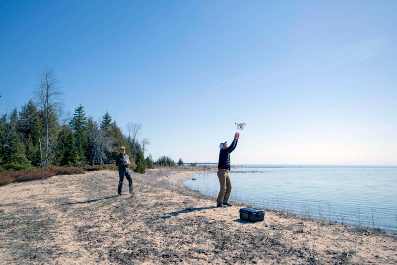 Oceans Unmanned pilot Brian Taggart brings a Phatom4 quadcopter down for a landing as pilot Matt Pickett gets ready to catch.