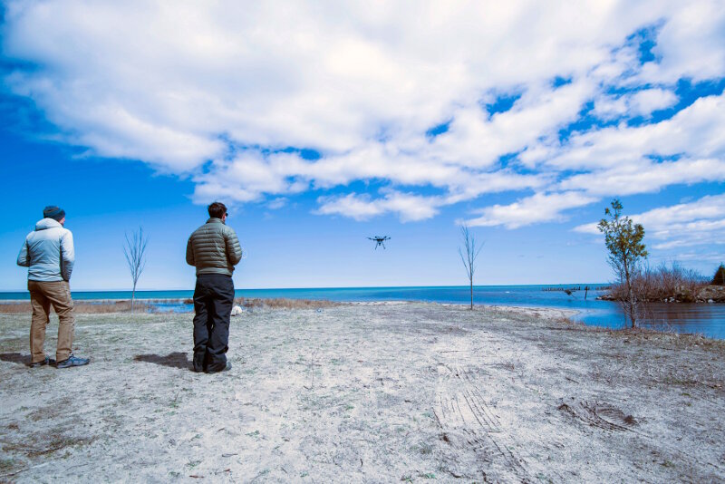 Pilot Matt Pickett looks on as pilot J.R. Gibbens takes off during a sunny break in an otherwise cloudy day.