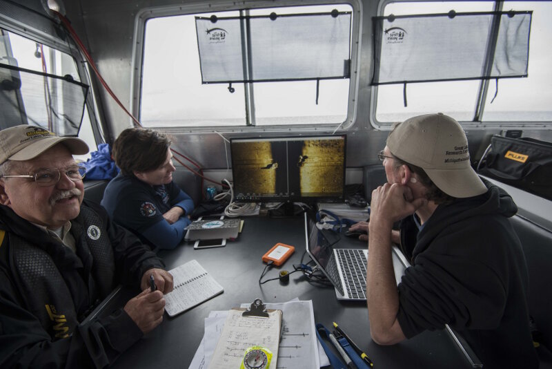 Dr. Guy Meadows and Chris Pinnow review AUV sonar data with Thunder Bay National Marine Sanctuary archaeologist Stephanie Gandulla onboard R/V Storm.