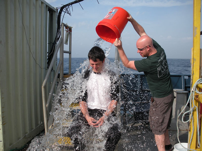 A new diver emerges from the sub and is greeted with a cold shower to celebrate the achievement of visiting the seafloor for the first time.