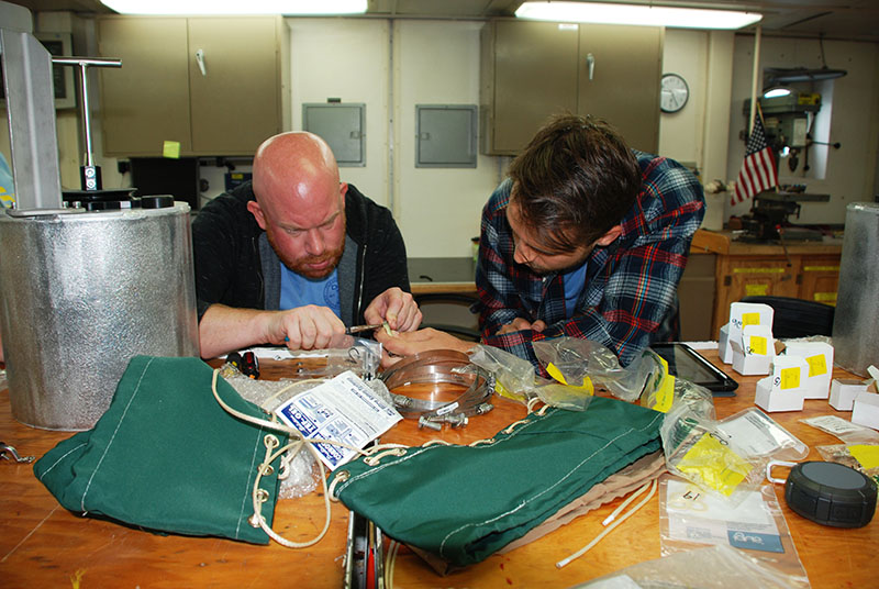 Jay Lunden and Ryan Gasbarro, both of the Cordes Lab at Temple University, work collaboratively to assemble a newly-built mussel pot. These mussel pots will be used on Alvin to collect mussel communities during dives at seep locations. 