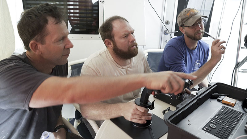 Eric Terrill, and Andrew Pietruszka look on as ROV operator, Bob Hess, expertly manipulates the team’s ROV in the deep waters of Papua New Guinea.