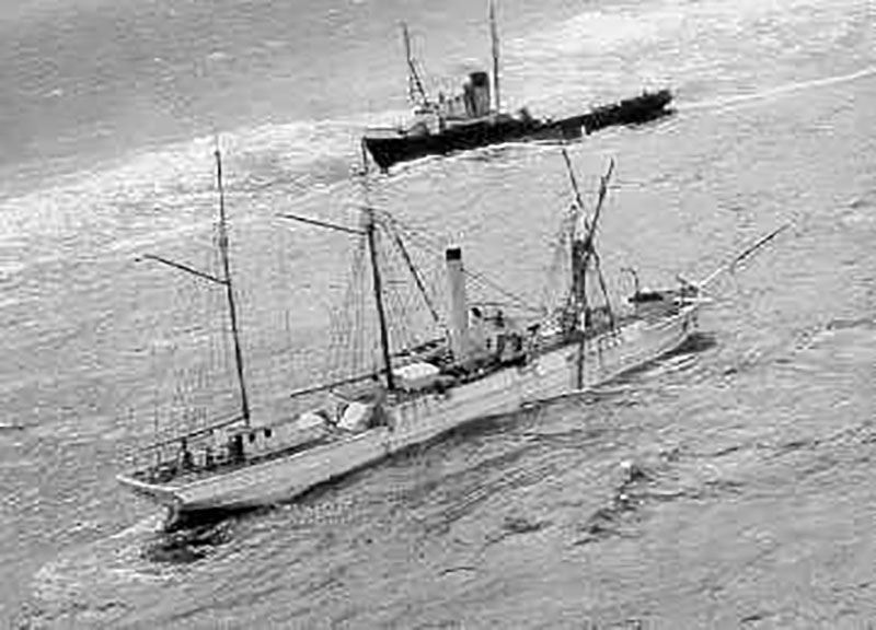 Last known image of the famous cutter Bear not long before she took the final plunge to the bottom. Notice damaged rigging, high seas, and sea-going tug Irving Birch in the background.