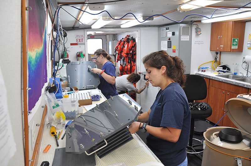 Maria Granquist, Jennie McClain, and Janessy Frometa assembling ARMS before deployment at McGrail Bank.