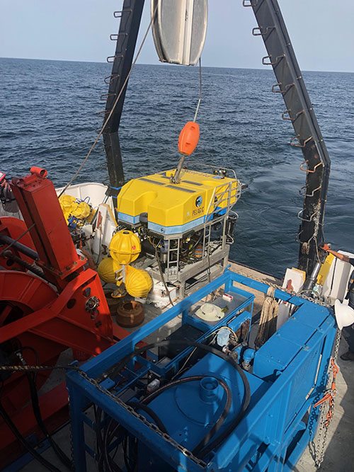 ROV Odysseus being deployed while carrying an acoustic lander with attached microbial recruitment experiments for deployment on the seafloor.
