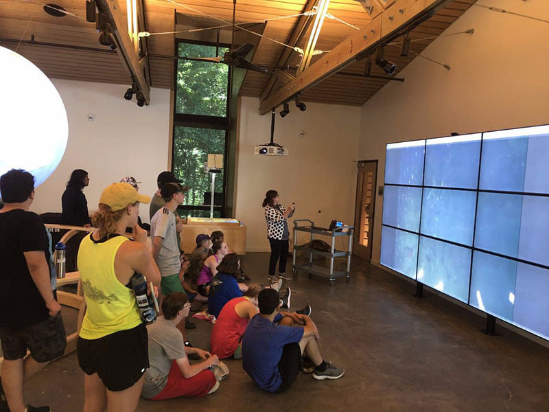 Ocean Science and Technology Camp (OSTC) students gathered in the Marine Education Center Exhibit Hall, telecommunicating directly with the R/V Point Sur.