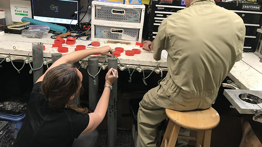 Dr. Amanda Evans in the ship’s lab writing field notes on each core sample.