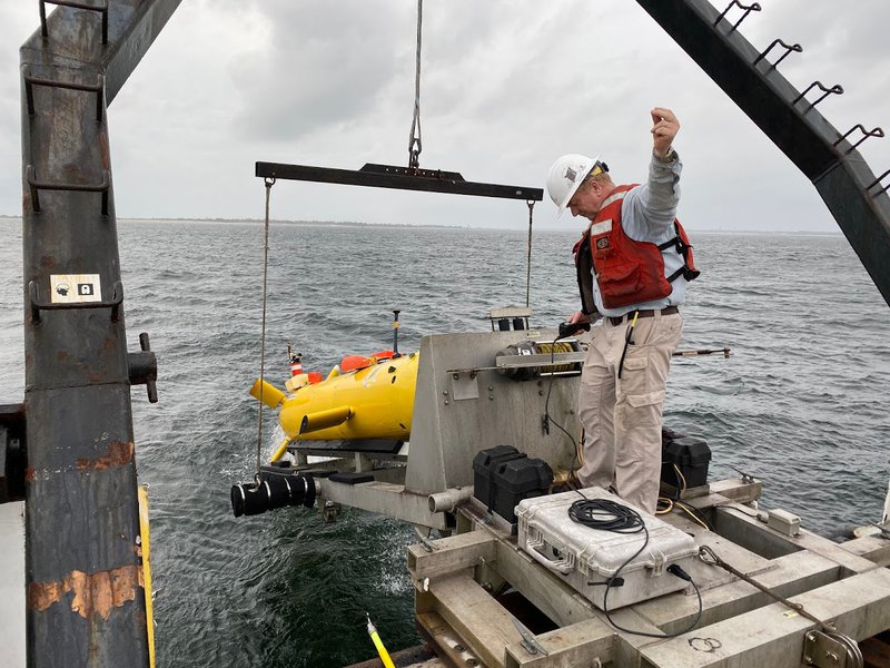 A test launch of the Eagle Ray autonomous underwater vehicle in the brackish waters of Pensacola Bay with Arne Diercks in the photo.