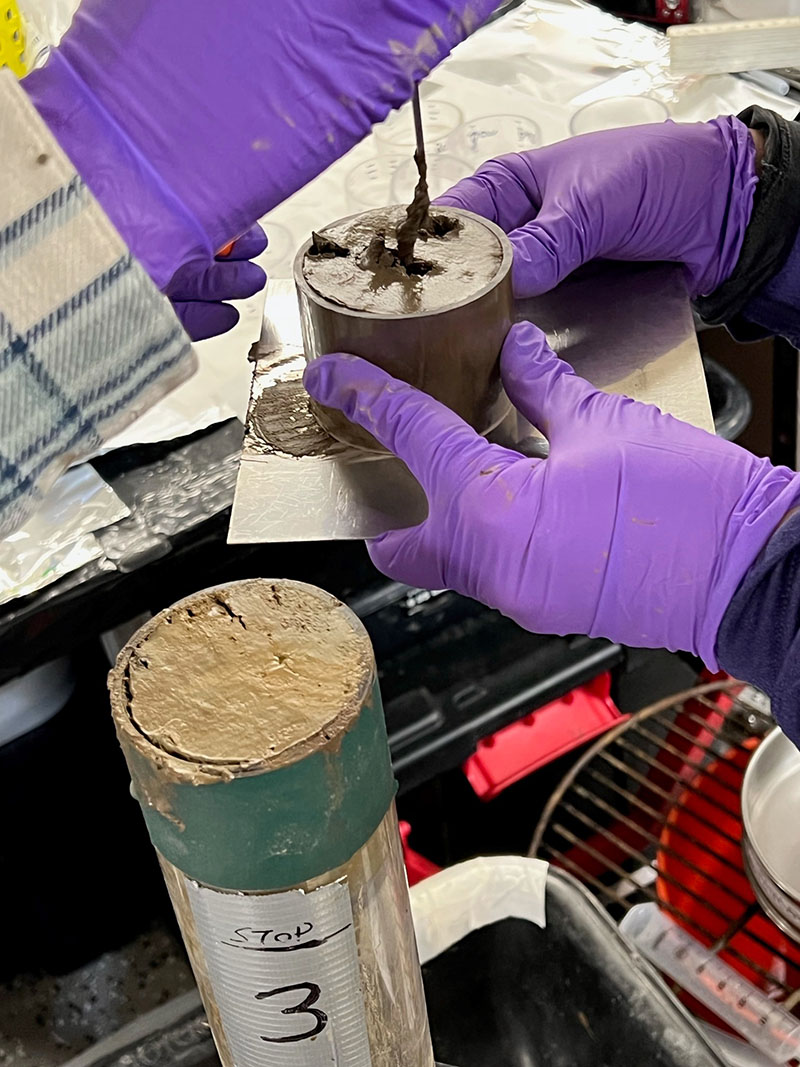U.S. Geological Survey scientists subsampling a clay-rich core during the Escanaba Trough: Exploring the Seafloor and Oceanic Footprints expedition. They will analyze the core for microbes and small infaunal creatures that live below the seafloor.