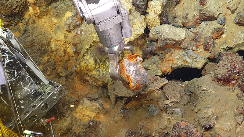 Woods Hole Oceanographic Institute's remotely operated vehicle Jason gathers a mineral sample from the seafloor at Escanaba Trough during the Escanaba Trough: Exploring the Seafloor and Oceanic Footprints expedition.