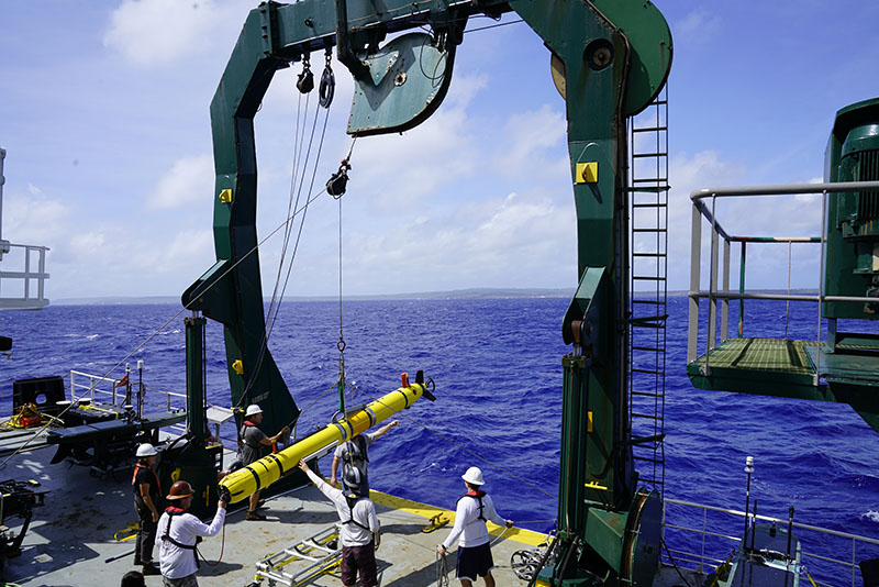 Launching a REMUS 600 vehicle from the A-frame of Research Vessel Kilo Moana during the Deepwater Surveys of World War II U.S. Cultural Assets in the Saipan Channel expedition. The vehicle is raised, then the A-frame is moved aft, over the water, and the vehicle can then be lowered to the sea surface. Taglines help ensure that after the vehicle is released, the brailer does not swing and can be controlled as it is lowered onto the deck.