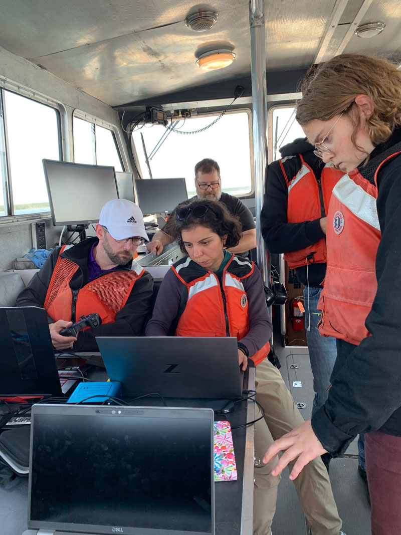 The project team works together aboard the R/V Storm to analyze data collected during marine robot operations.