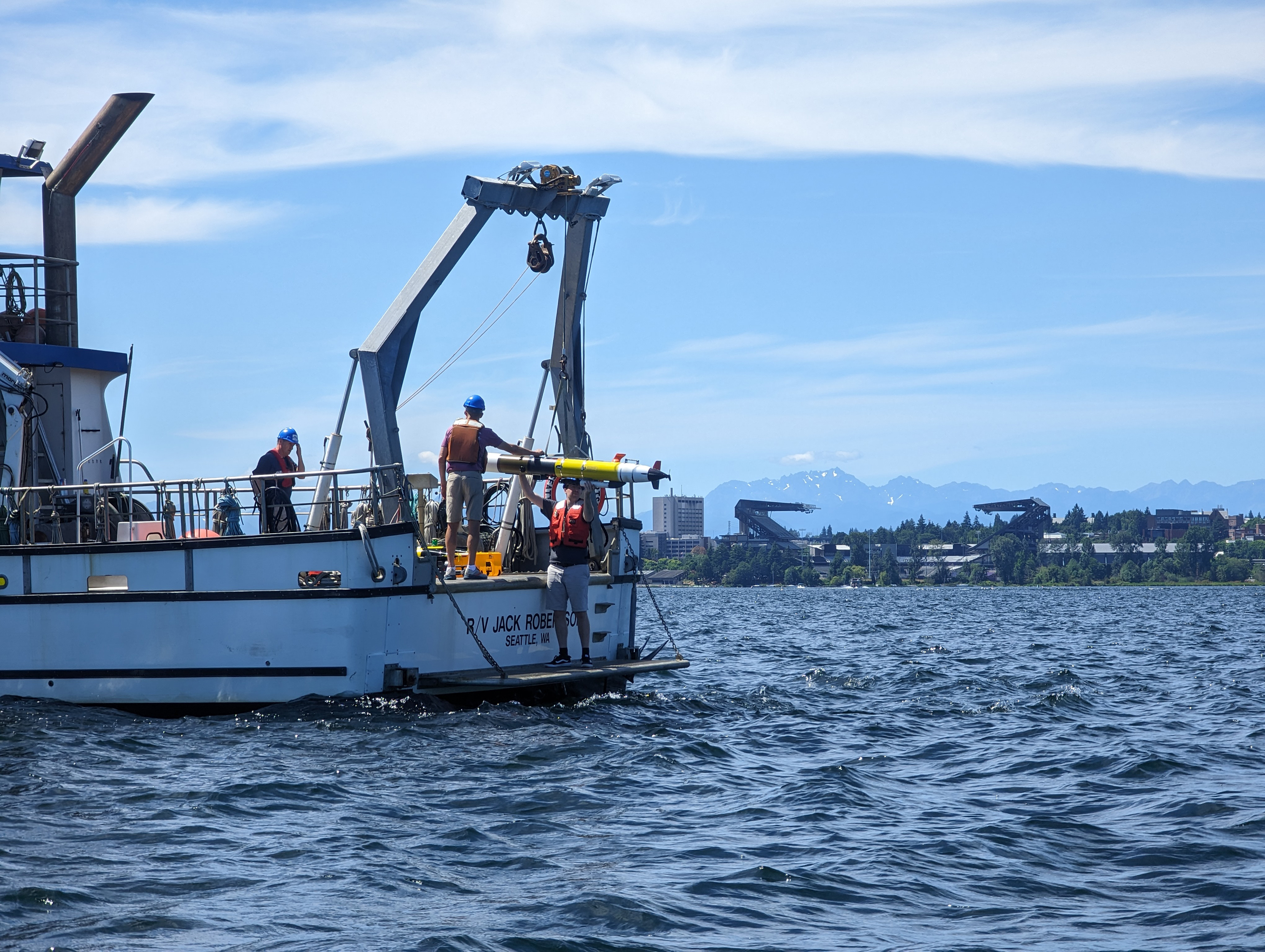 A REMUS 100 autonomous underwater vehicle being deployed from Research Vessel <i>Jack Robertson</i> during calibration in Seattle's Lake Washington.