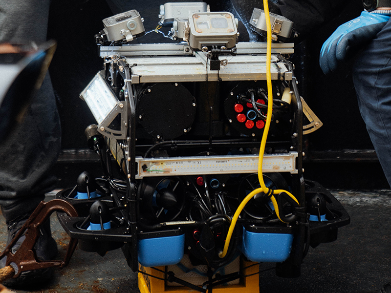 The expedition team will utilize a remotely operated vehicle-based underwater photogrammetry system named MURAKUMO, developed by World Scanning Project. MURAKUMO is an accessory for ROVs that mounts 5-8 cameras and strobe lights. It is designed for underwater photogrammetry and remains independent of the ROV itself, thus it can be applied to different ROVs depending on the research needs. For this project, MURAKUMO is housed on a BlueRov2, which has depth capabilities up to 250 meters (~820 feet). The cameras mounted on MURAKUMO face different directions, resulting in the photos covering a variety of angles; the photos can then be used to create a digital model.