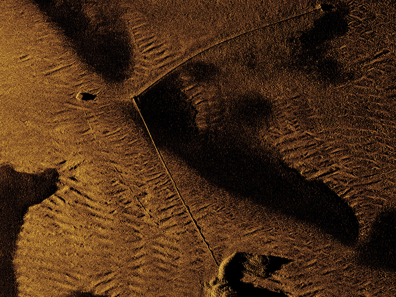 Synthetic aperture sonar imagery of anti-submarine net mooring observed on the seafloor.