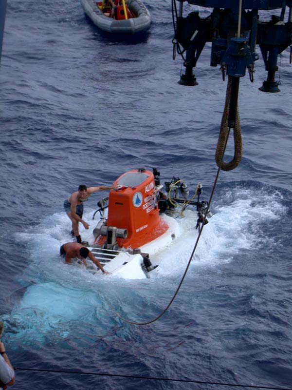 Alvin is recovered in rough seas. Standby boat picks up divers once the sub is hooked.