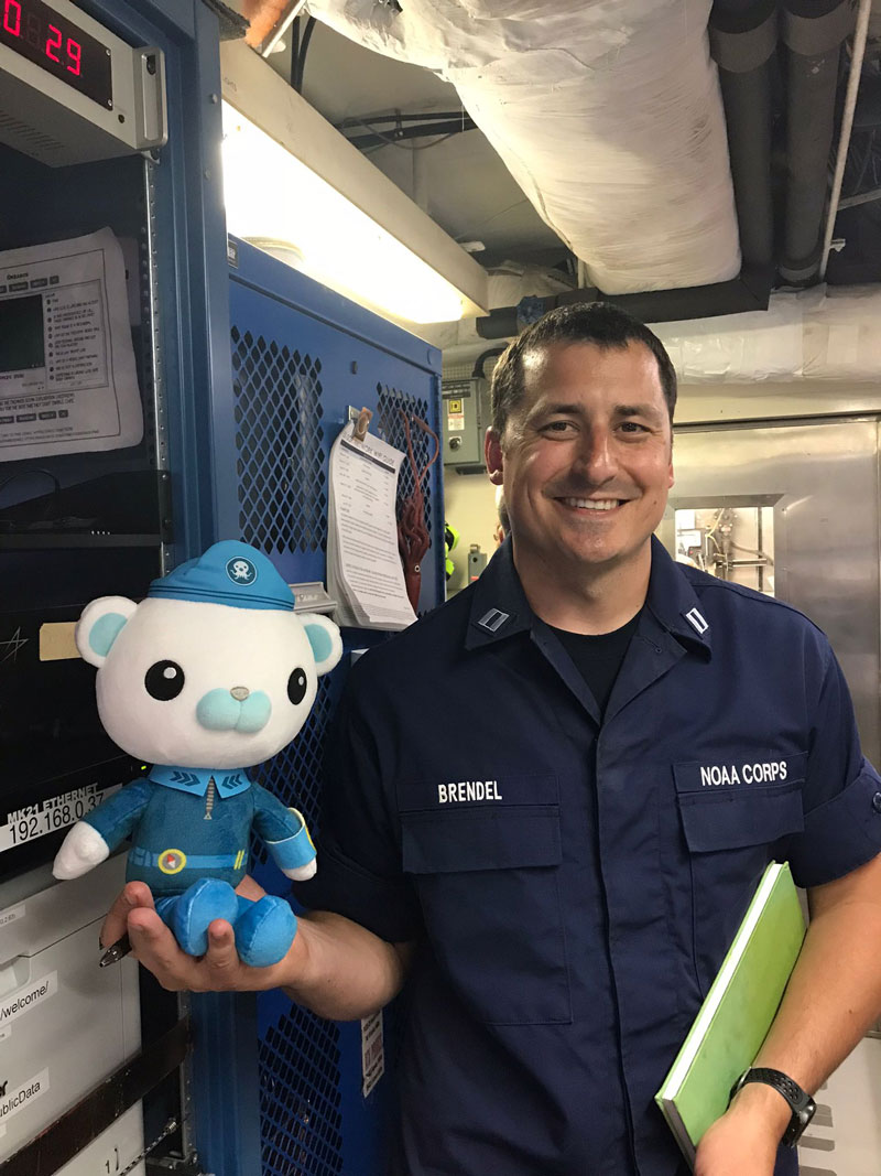 Captain Barnacles poses with Lieutenant Hunter Brendel, Operations Officer for NOAA Ship Okeanos Explorer. LT Brendel is a member of the NOAA Commissioned Officer Corps (NOAA Corps), which is one of the nation’s eight uniformed services. NOAA Corps officers, along with civilian crew members, operate Okeanos Explorer as part of NOAA's fleet managed by the NOAA Office of Marine and Aviation Operations. Expeditions couldn’t happen without them!
