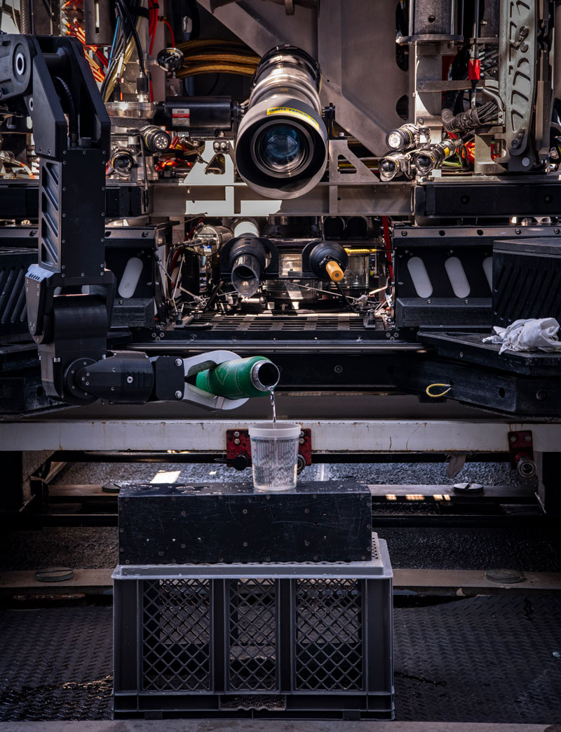 During the second Voyage to the Ridge 2022 expedition, the team from the Global Foundation for Ocean Exploration took some time to practice using remotely operated vehicle Deep Discoverer’s manipulator arm. Deft maneuvering of these arms is important to the successful collection of biological and geological samples. In this image, the pilots use Deep Discoverer’s manipular arm to pour water into a glass.