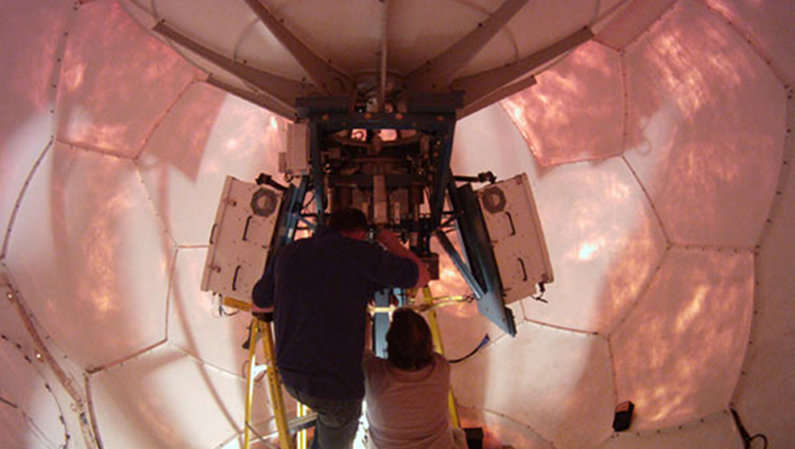 Technicians work to repair the satellite antenna in the VSAT dome.