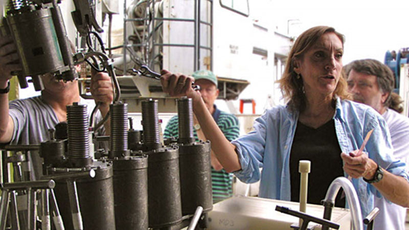 Dr. Karen Von Damm makes adjustments to the sampling basket on the DSV Alvin, in preparation for a dive following a 2005-2006 eruption on the East Pacific Rise spreading center. Dr. Von Damm is remembered for her seminal research on the processes controlling hydrothermal fluid chemistry, along with her commitment to teaching and advising young scientists.