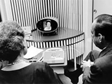 The technical components of telepresence are older than you might think: Here, Mrs. Lyndon B. Johnson in Washington, DC, uses the Bell Labs PicturePhone to call Dr. Elizabeth Wood and then-Major Robert F. Wagner in New York City, in 1964.