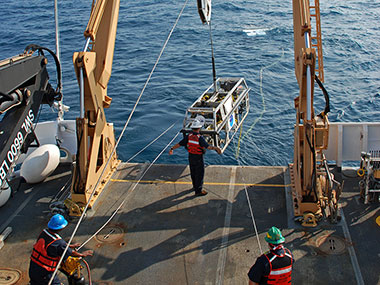 AB Kelson Bracey (left), BGL Jerrod Hozendorf (center) and AB Doug McKay (right) launch Camera Sled Seirios from NOAA Ship Okeanos Explorer.